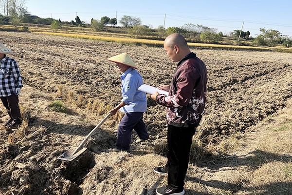 网格员在田间地头了解秋种情况，同时做好疫情防控工作宣传  李晶晶摄.jpg